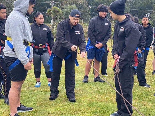 Students working together on a ropes course